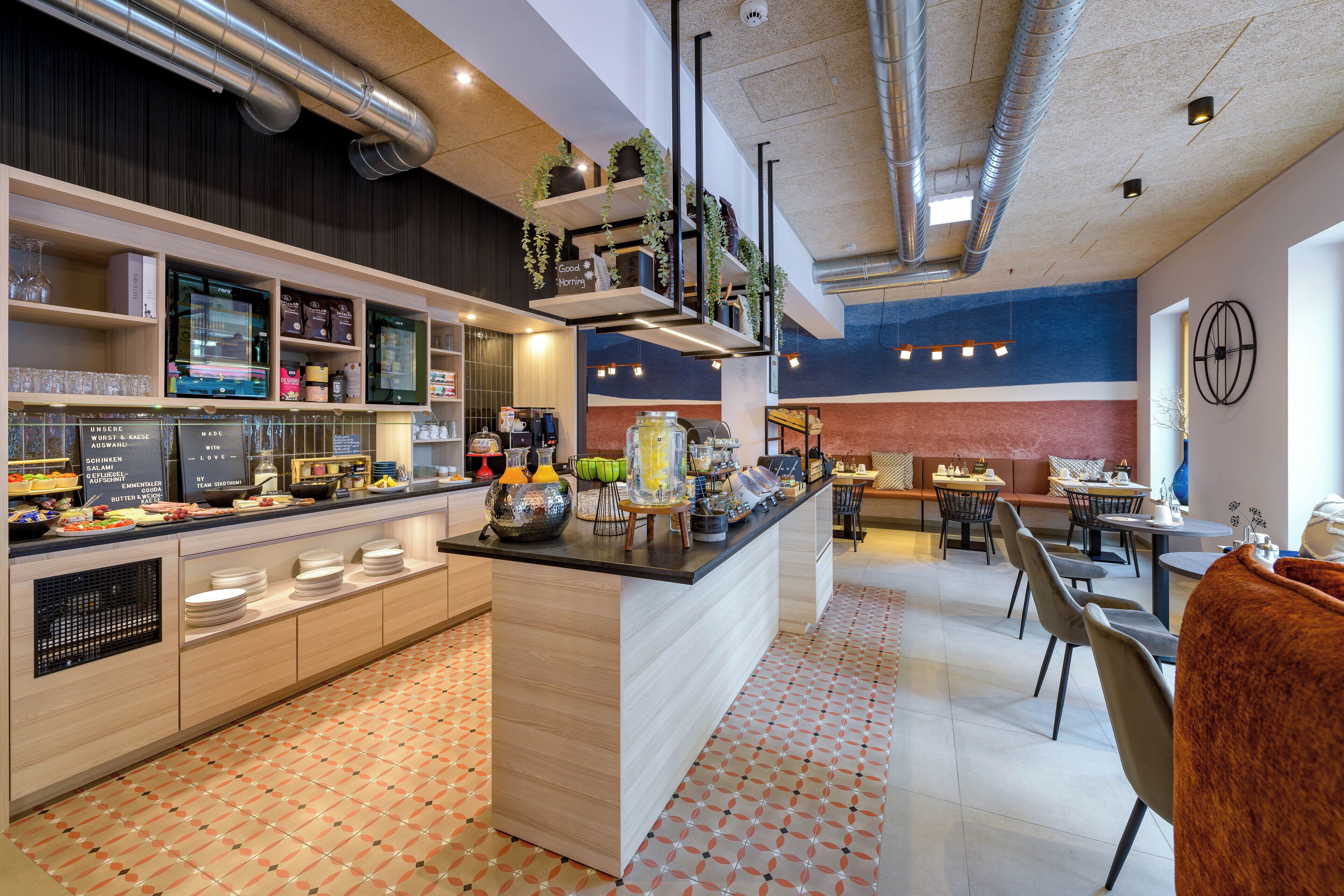A modern kitchen with a central island, built-in appliances, and a variety of food items and utensils.