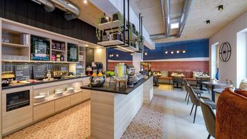 A modern kitchen with a central island, built-in appliances, and a variety of food items and utensils.
