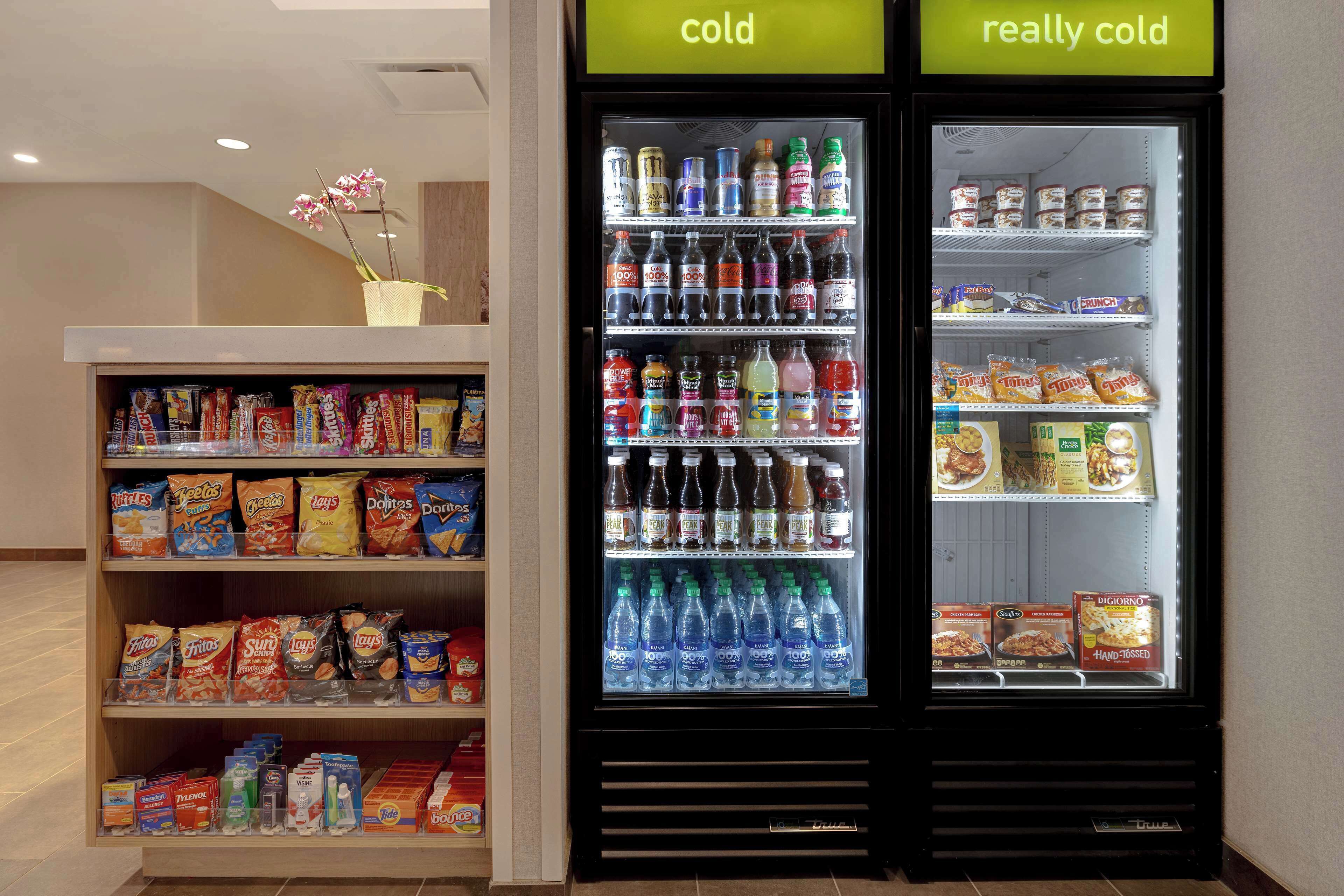 A vending machine stocked with beverages and snacks, including water, sodas, and chips.