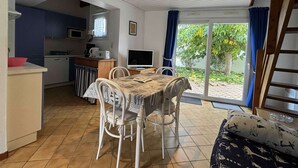 A compact kitchen with a dining area, a TV, and a view of the outdoors. - Family home near beach in Saint-Denis d'Oléron, enclosed garden (Saint-Denis-d'Oléron)