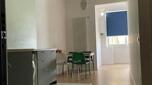 Eine moderne Küche mit Essbereich, Heizkörper und einem Fenster mit Jalousien.