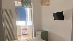 Ein Schlafzimmer mit Bett, Schreibtisch, Stuhl und kleinem Tisch.