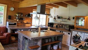 Une cuisine spacieuse dotée d’un grand îlot central, d’appareils électroménagers intégrés et de nombreux plans de travail.