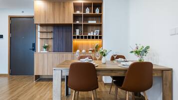 Un comedor moderno con una mesa de madera, sillas marrones y un armario empotrado de madera con estantes.