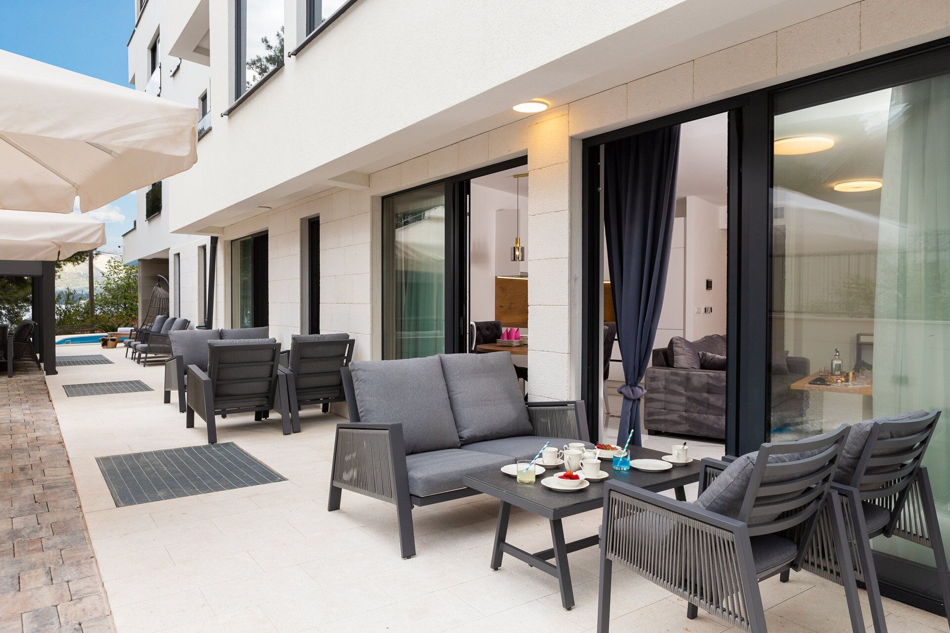 Patio esterno con posti a sedere, una piscina e un'area pranzo.