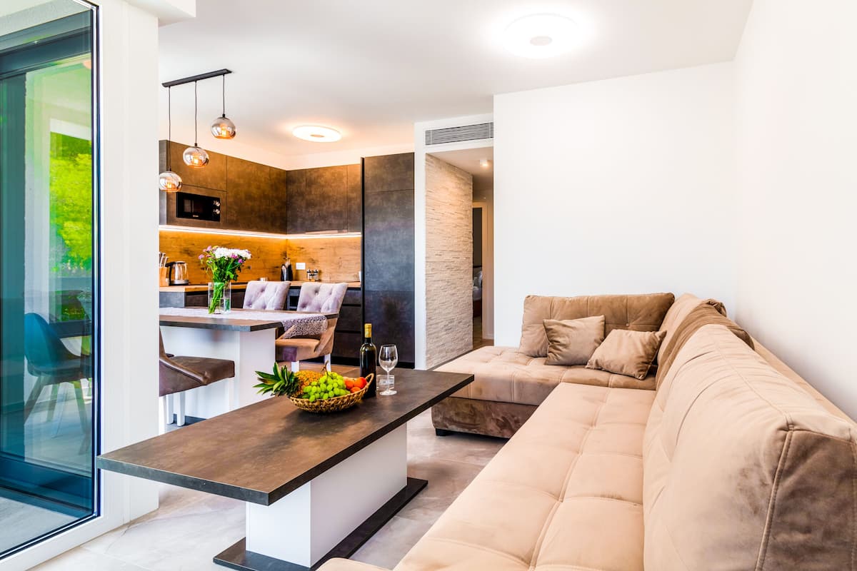 A modern kitchen with dark cabinets, a central island, and pendant lighting.
