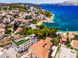 A coastal town with a marina, residential buildings, and a beach. - Beach Villa Valentina (Okrug)