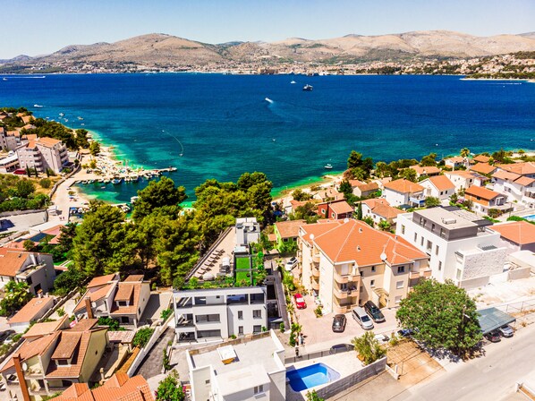 A coastal town with buildings, a beach, and boats on the sea. - Beach Villa Valentina (Okrug)