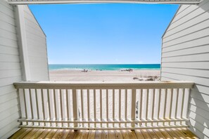 Una terraza de madera con vista a una playa y al océano.