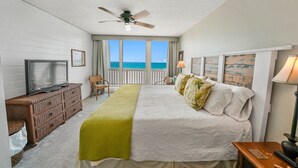 A hotel room with a bed, a television, a wooden dresser, and a view of the ocean. - Very Merry - Renovated Gulf-Front Escape, Steps To Beach (Panama City Beach)
