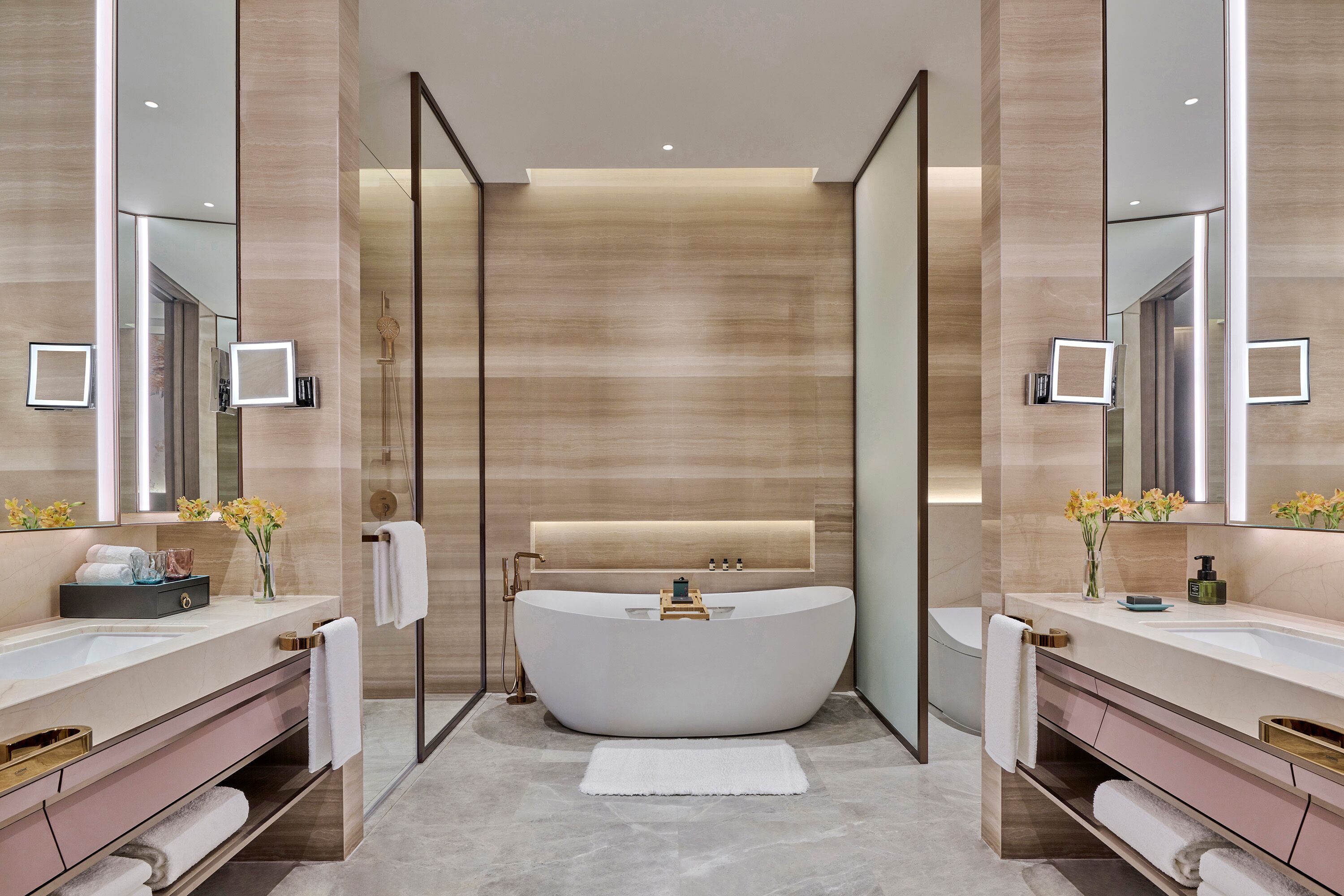 A modern bathroom with a freestanding bathtub, dual sinks, and a large mirror.