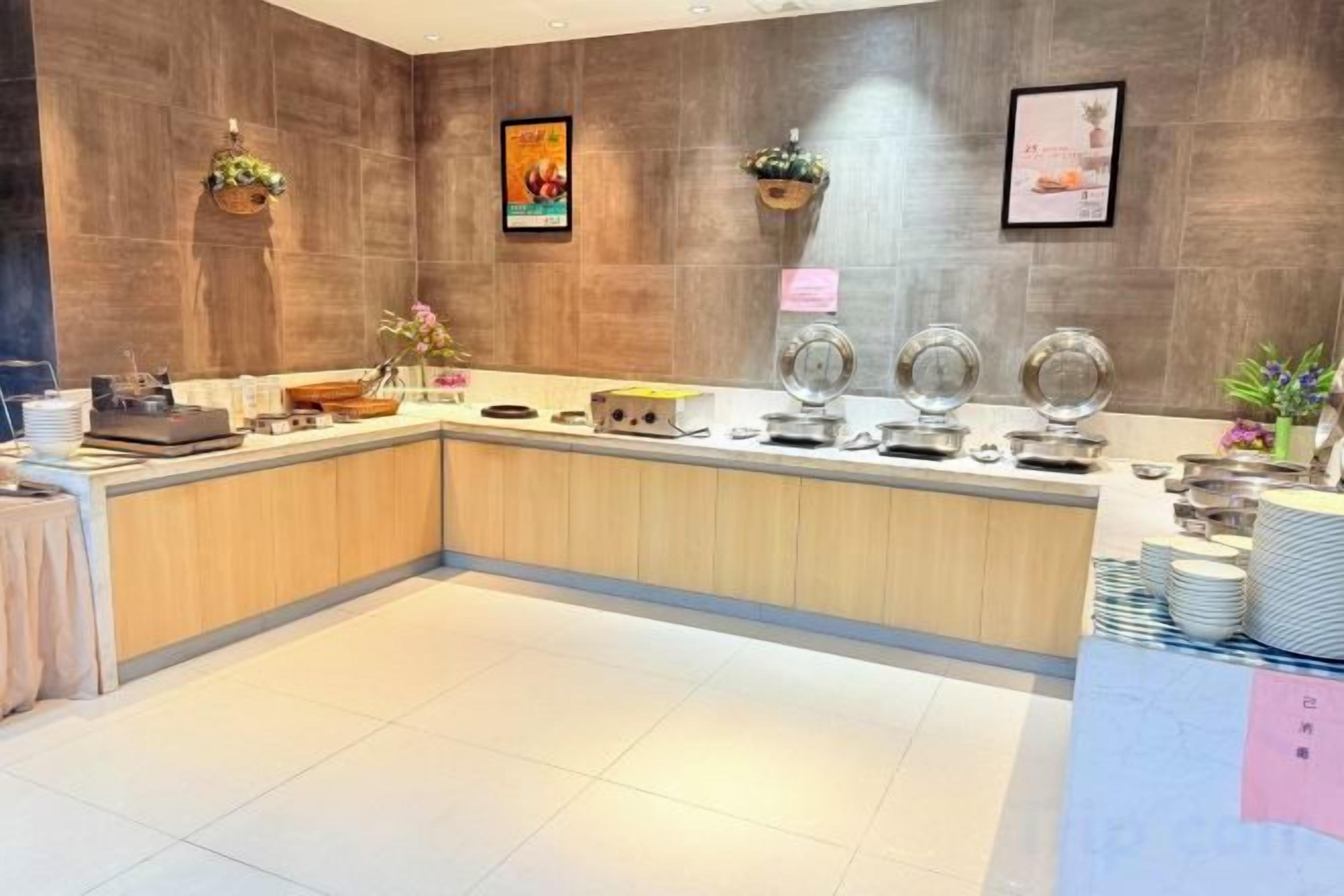 A modern reception area with a wooden reception desk, a coffee station, and a wall-mounted display.