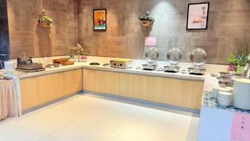 A modern reception area with a wooden reception desk, a coffee station, and a wall-mounted display.