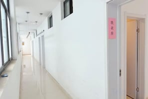 A hallway with a sign indicating a laundry room, a door, and a window on the left. - Jinjiang Star Hotel (Yancheng Jinfeng South Avenue) (Yancheng)