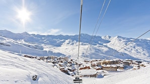 A ski lift cable with a snowy mountain landscape in the background.