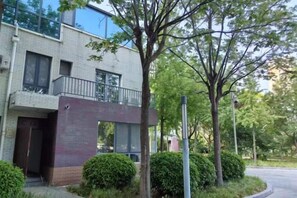 Un edificio moderno con fachada plana, ventanas amplias y un balcón.