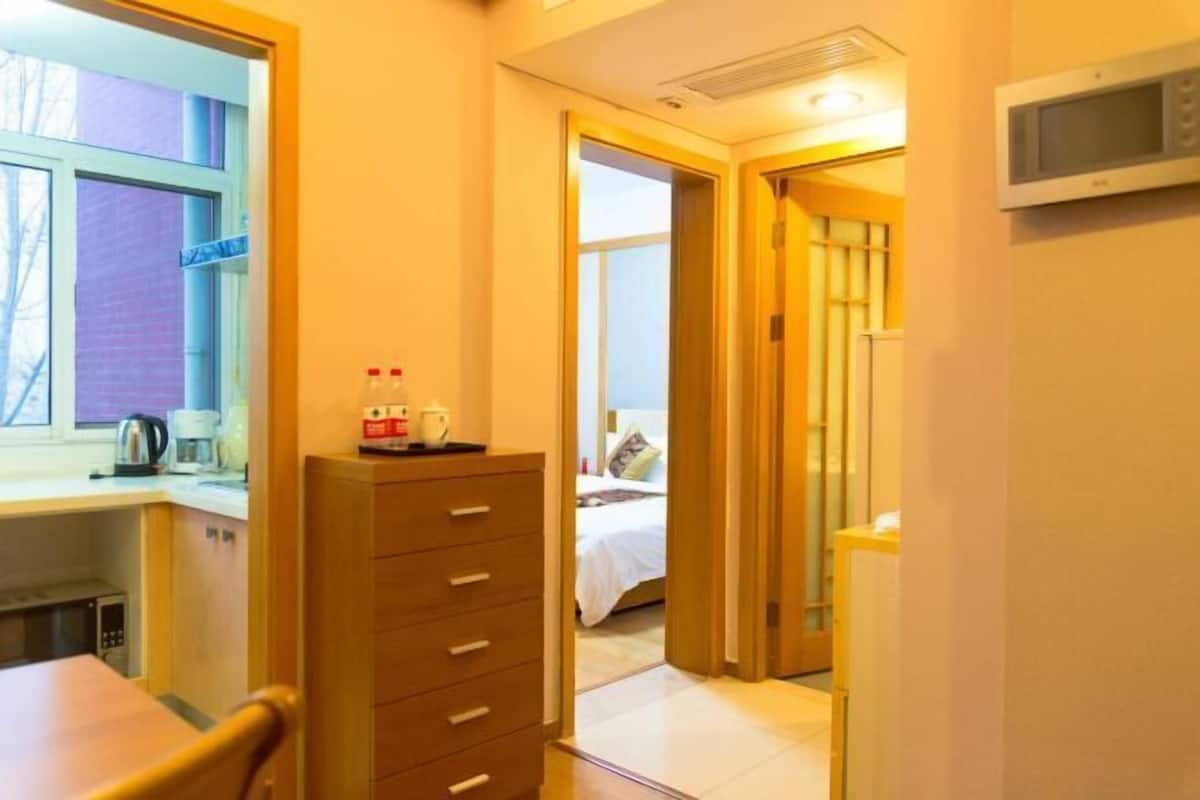 Ein Hotelzimmer mit einem Bett, einem Schreibtisch mit Wasserkocher, Mikrowelle und einem Kleiderschrank.