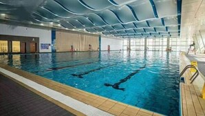 An indoor swimming pool with clear lane markings, a tiled floor, and a modern ceiling design. - Keyuan Business Hotel (Jining)