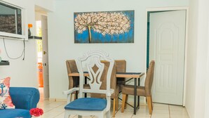 A dining area with a wooden table, chairs, and a blue sofa. - Cozy house with 3 bedrooms, a 10-minute walk to the Samana boardwalk. (Samaná)
