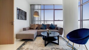 A modern living room with a sectional sofa, a round coffee table, and a blue chair.