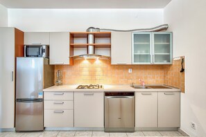 A compact kitchen with a built-in microwave, stainless steel refrigerator, dishwasher, and a gas stove. - Holiday apartment Sandra in suburb of Pula (Pula)