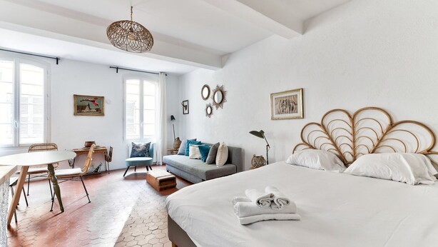 Une chambre spacieuse avec un grand lit, une table à manger et un coin salon.