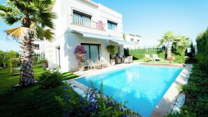 A modern two-story house with a swimming pool, surrounded by lush greenery and palm trees. - Beautiful Villa  with heated pool Agadir! (Agadir)