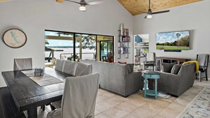 A spacious living area with a dining table, sofas, and a TV.