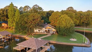 A lakeside property with a house, dock, and a well-maintained lawn.