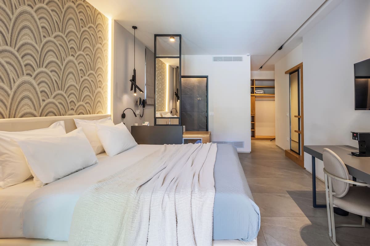 Ein modernes Hotelzimmer mit einem großen Bett, einem Schreibtisch und einem Spiegel.