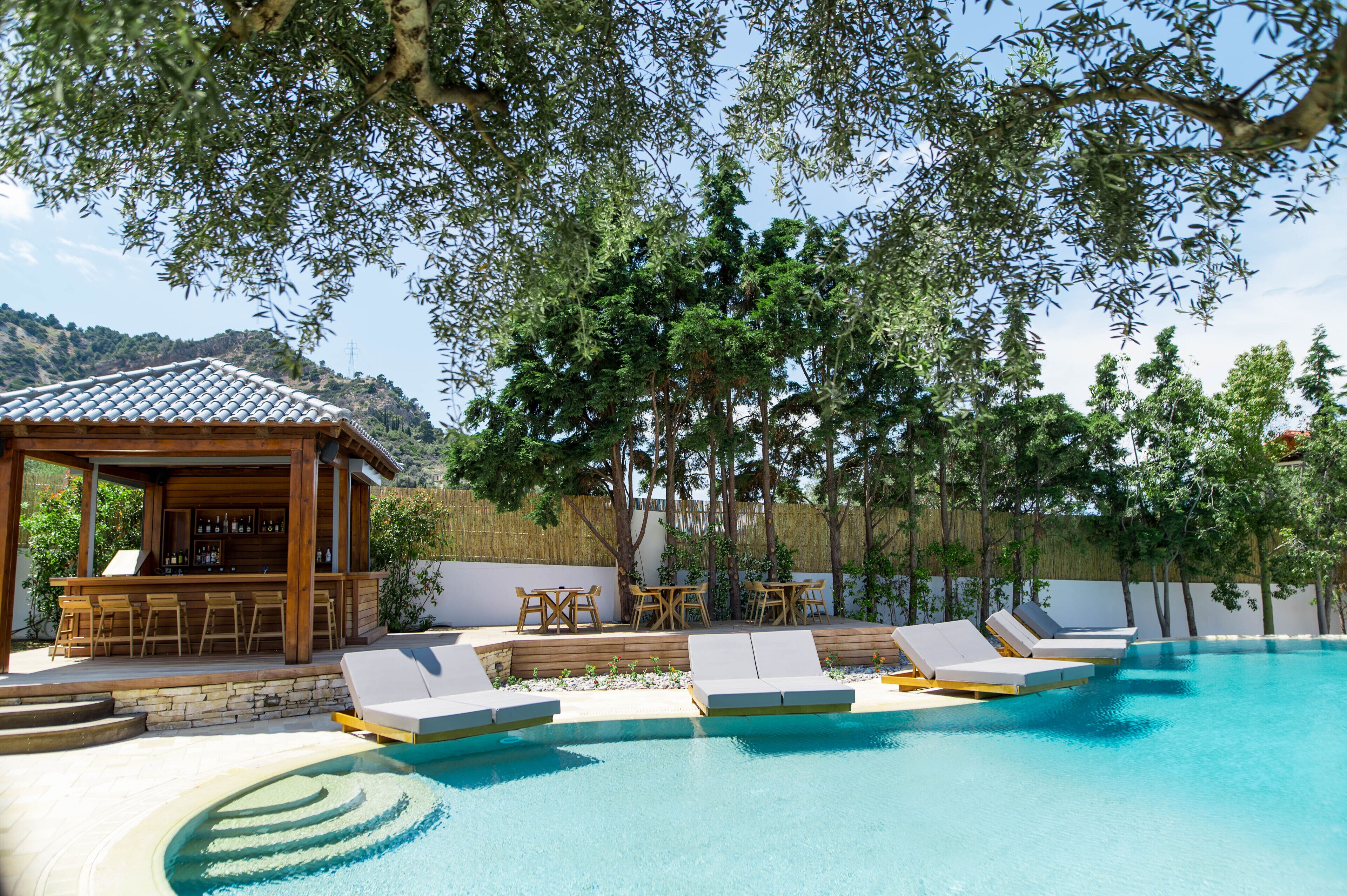 A pool area with lounge chairs and a bar.