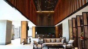 Eine moderne Lobby mit Sitzgelegenheiten, einer Rezeption und einer Bar.