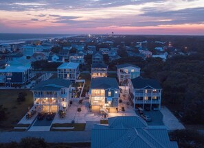 A coastal residential area with houses featuring large windows and balconies, likely offering ocean views. - Sally's Sandcastle in Oak Island boasts 7 bedrooms, ocean views, and a private pool. (Oak Island)