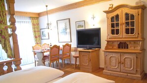 A room with a bed, a television, wooden furniture, and framed pictures on the wall. - Apartment 14 (Rottach.Apartments) Holiday apartment on Lake Tegernsee (Rottach-Egern)