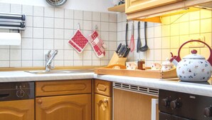 A kitchen with wooden cabinets, a dishwasher, an oven, and a skylight. - Apartment 14 (Rottach.Apartments) Holiday apartment on Lake Tegernsee (Rottach-Egern)