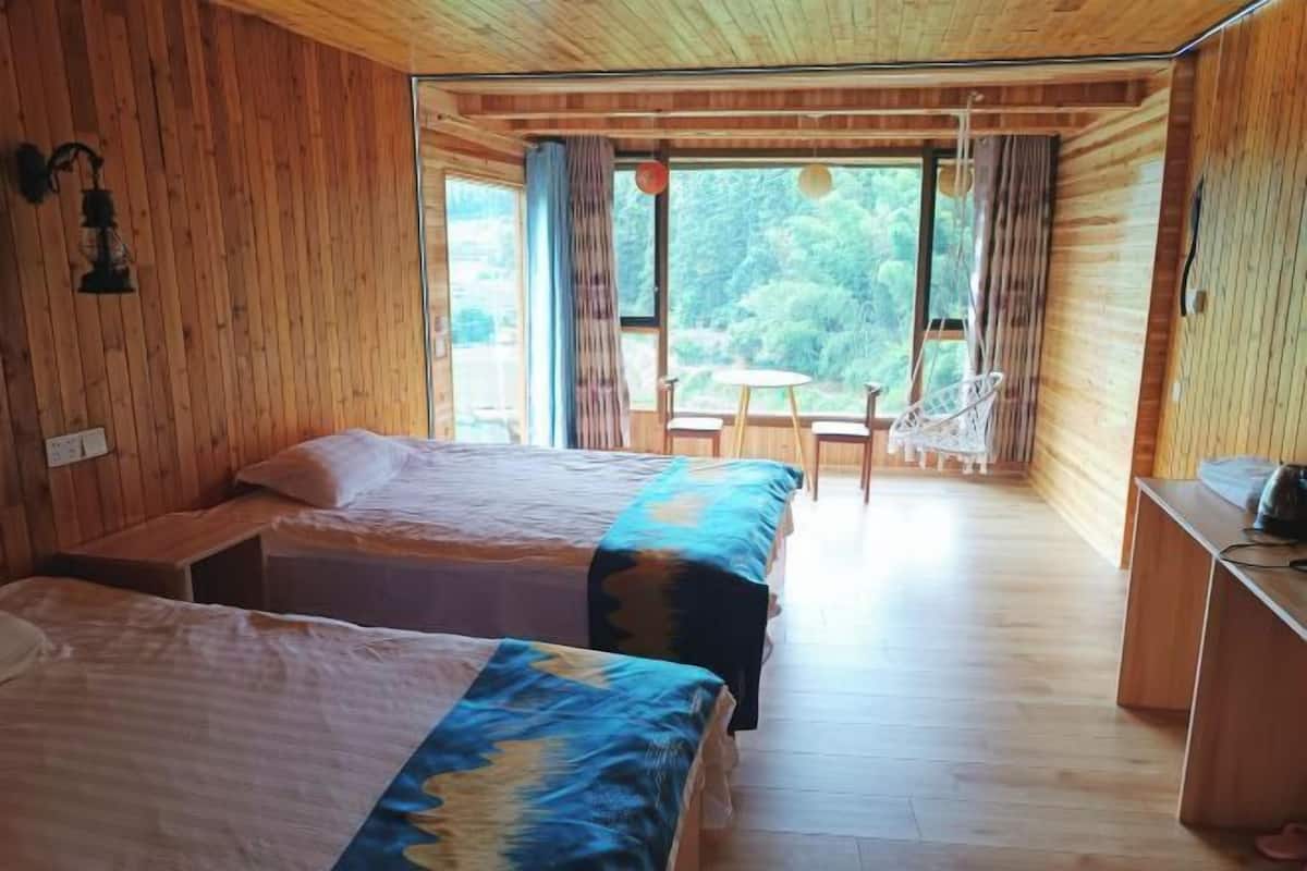 Una cabaña de madera con dos camas, una zona de comedor y vistas al exterior.