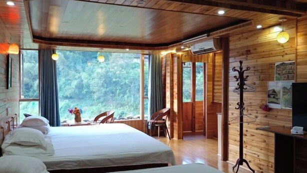 Une cabane en bois avec deux lits, un coin repas et une vue sur la forêt.