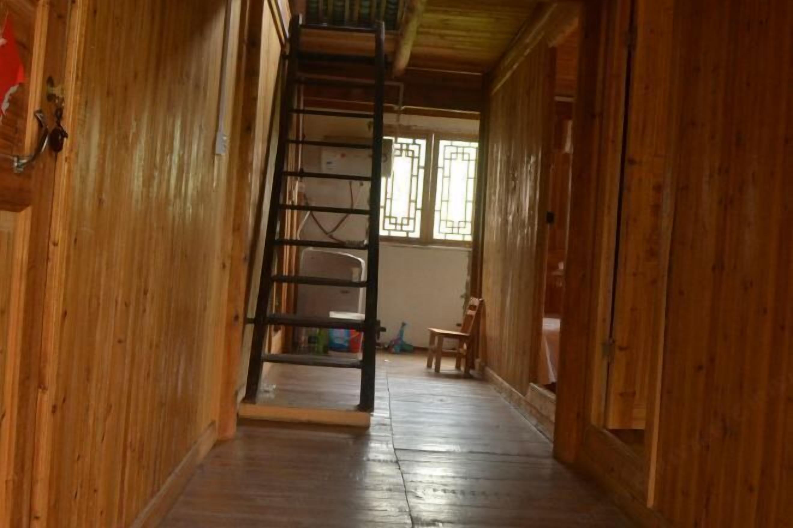 A wooden interior with a wooden staircase leading to a room.