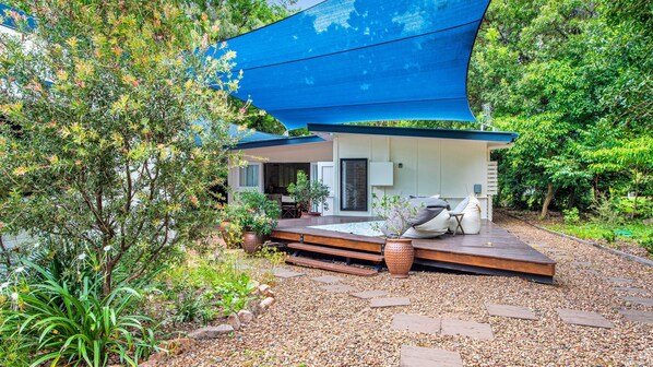 Relax in a serene, setting surrounded by lush greenery and a shaded outdoor space.