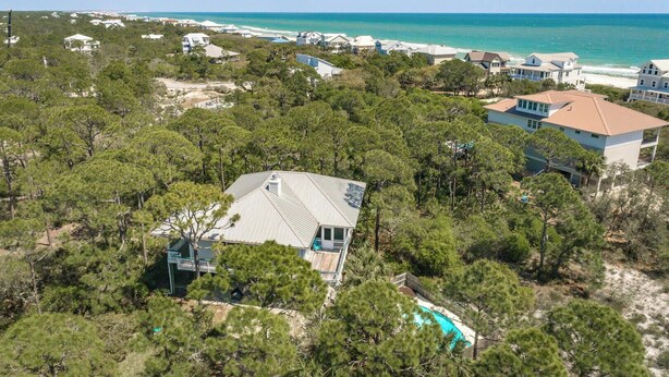 Un área residencial costera con casas, una piscina y vistas al océano.