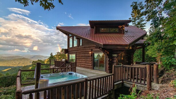 A log cabin with a hot tub on a deck, surrounded by a forest and mountains. - Ahh Time Flies at a mountain cabin with scenic view (Bryson City)