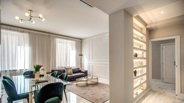 A modern living room with a glass dining table, dark green chairs, a brown sofa, and a marble floor. - Spacious Luxury Family Home - 6 AC / WIFI / Heating / Elevator (Roma)