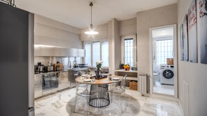 A modern kitchen with a central island, stainless steel appliances, and a marble floor. - Spacious Luxury Family Home - 6 AC / WIFI / Heating / Elevator (Roma)