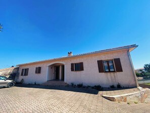 A single-story house with a tiled driveway and a parked car. - Apartments in private residence with sea view, quiet and close to shops and beaches. (Solenzara)
