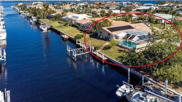 A marina with boats docked, a house with a pool, and a red circled area highlighting a specific section. - Magical Family Oasis - Diamond Sunsets in Vacation Land -Sleeps10 -Pet Friendly  (Punta Gorda)