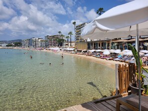 A beachside hotel with clear waters, sun loungers, and umbrellas. - Air-conditioned studio in the city center with a view of the ocean (Antibes)
