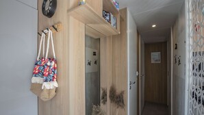 Un corridoio con pareti in legno, una sveglia, una porta e una pianta decorativa.