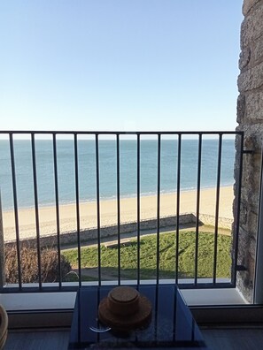 Ein Balkon mit Blick auf den Strand und das Meer.