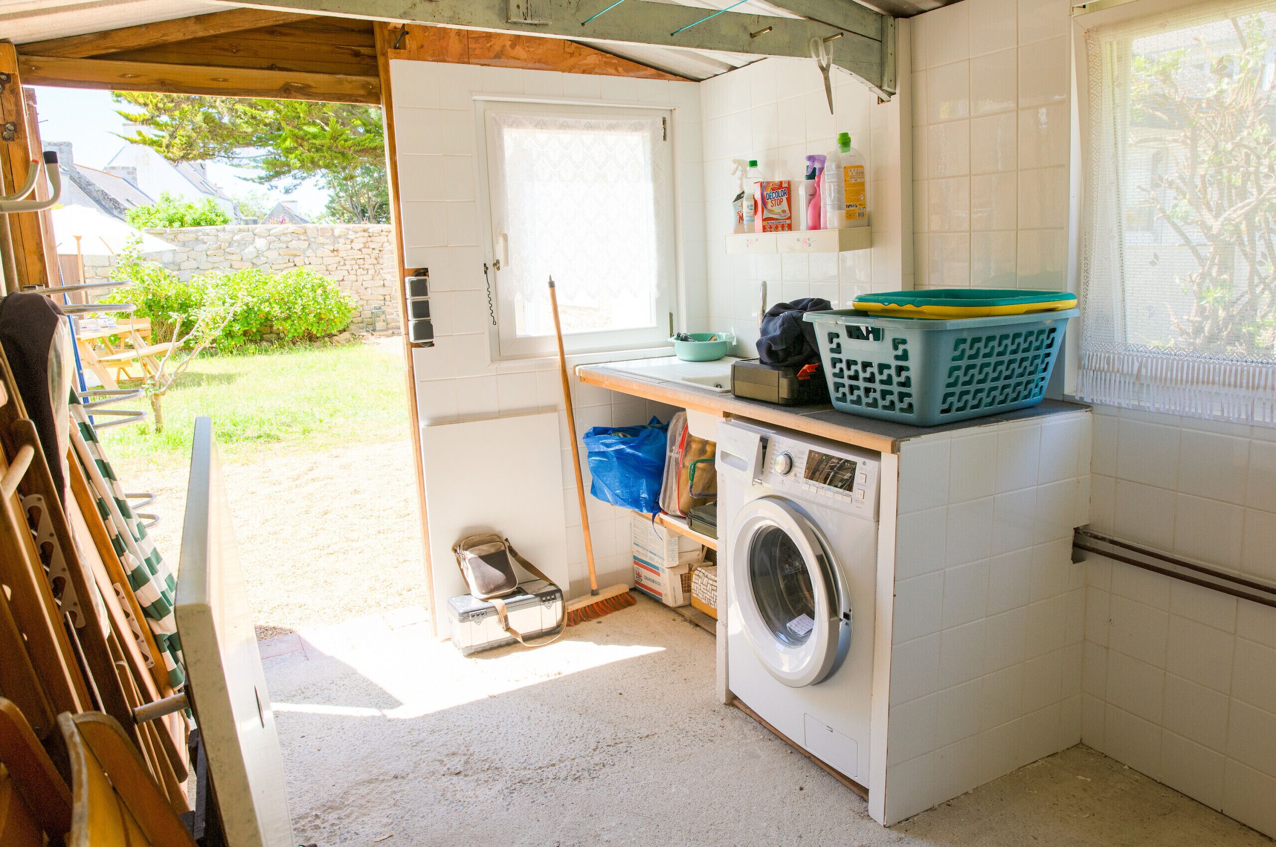 Une buanderie équipée d’un lave-linge, d’un étendoir et d’une fenêtre donnant sur l’extérieur.