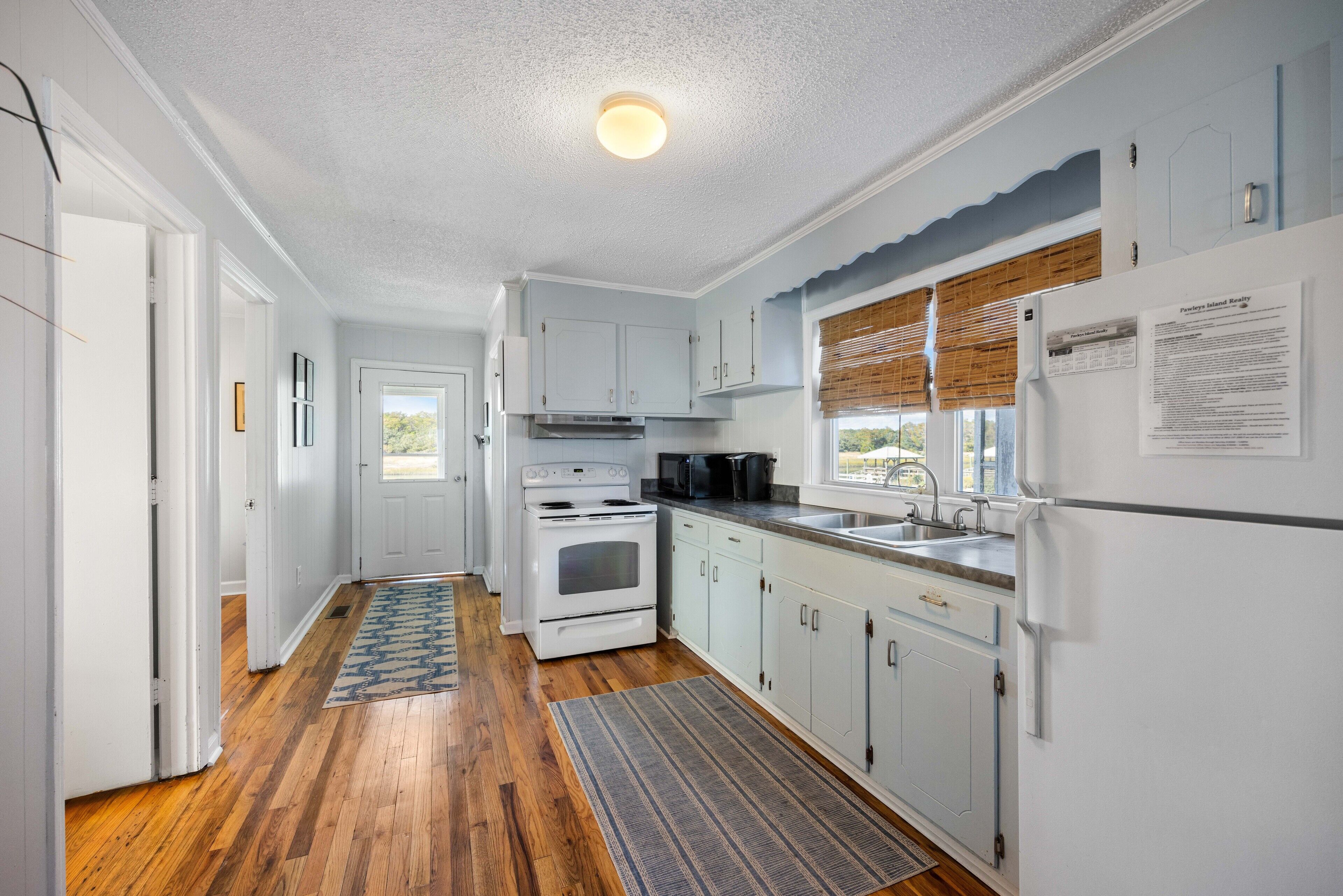 A kitchen with white cabinets, a stove, and a refrigerator.